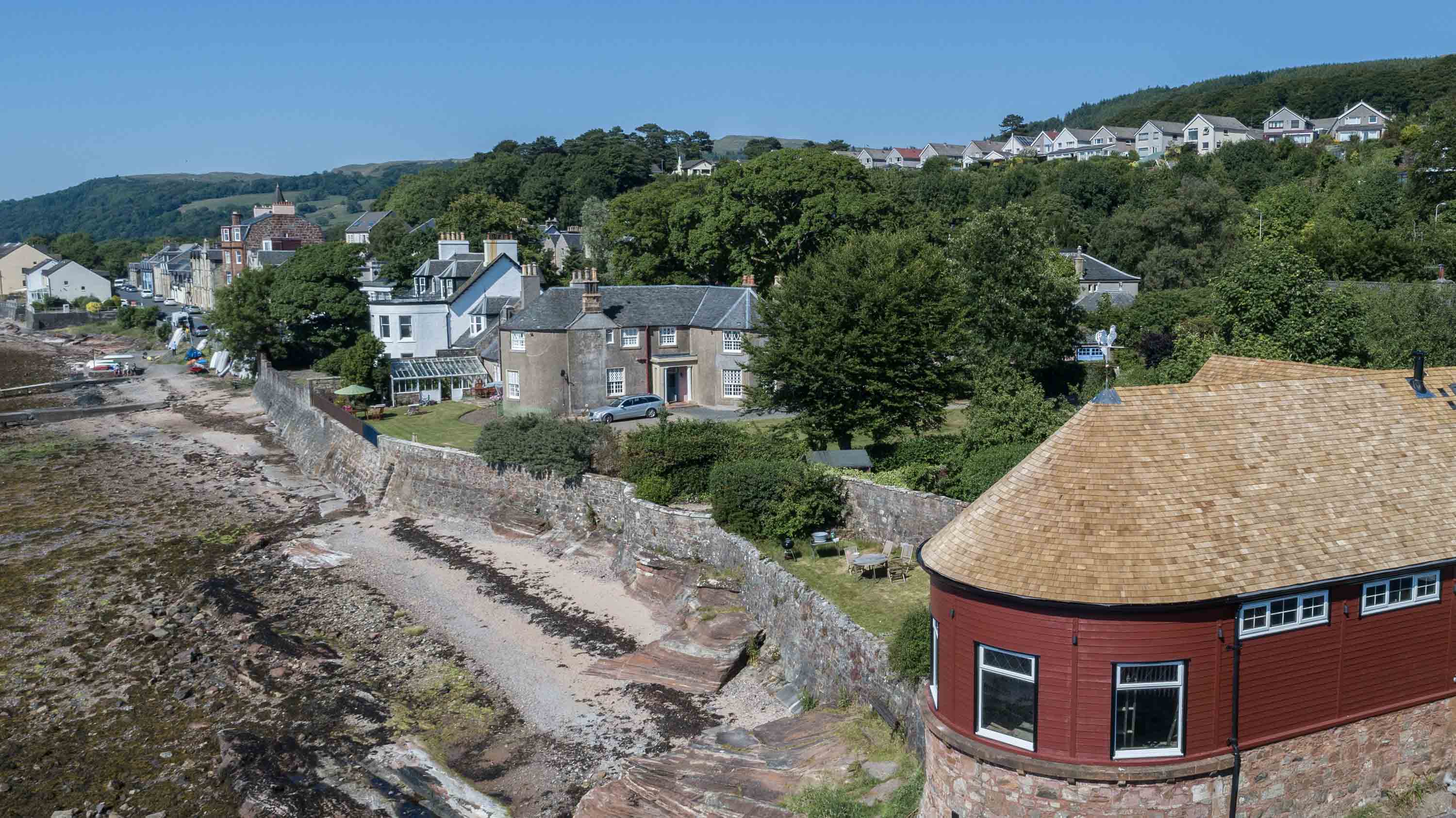 A house overlooking a cliff with a cedar shingle roof.