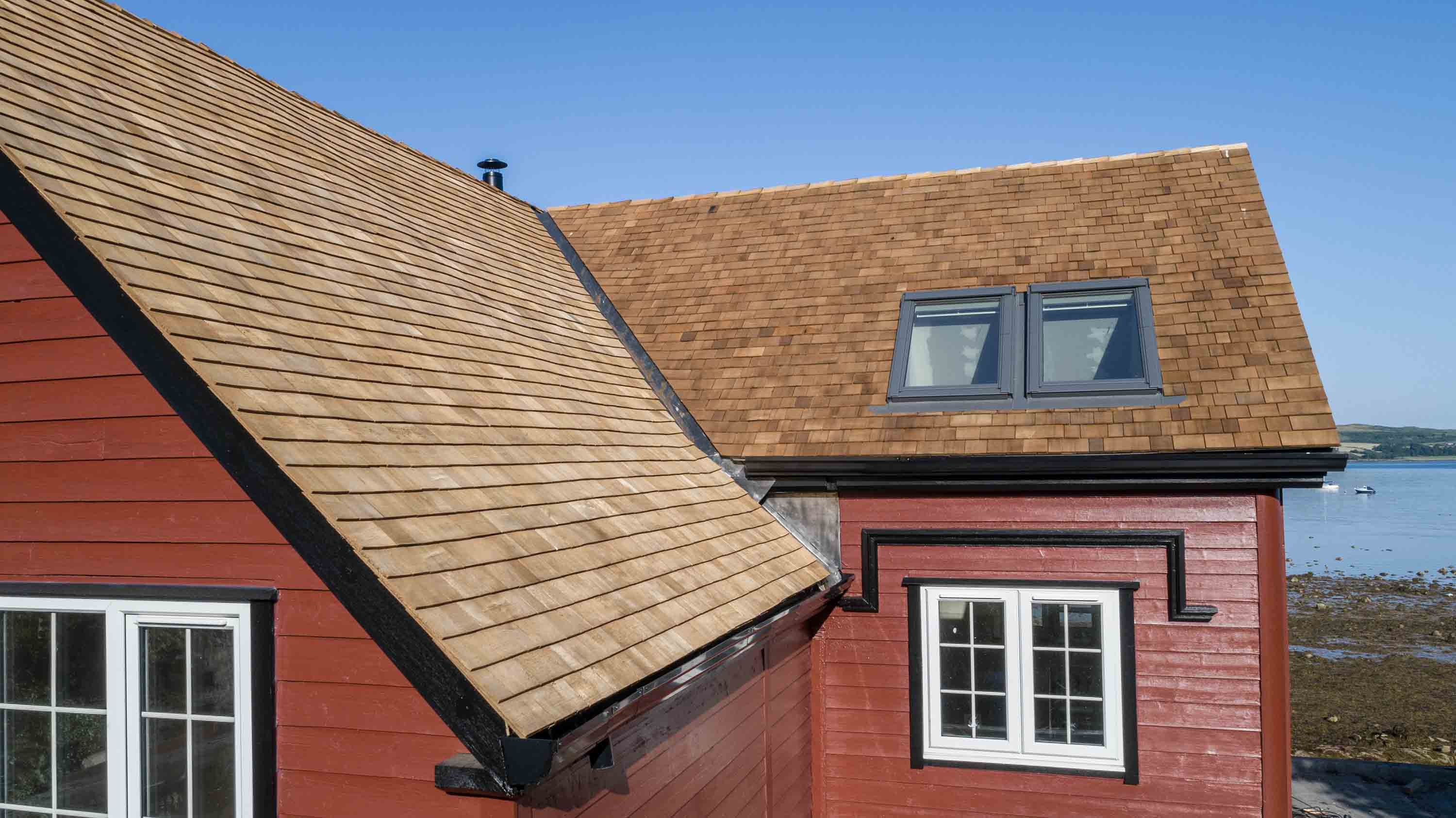 A house overlooking a cliff with a cedar shingle roof.