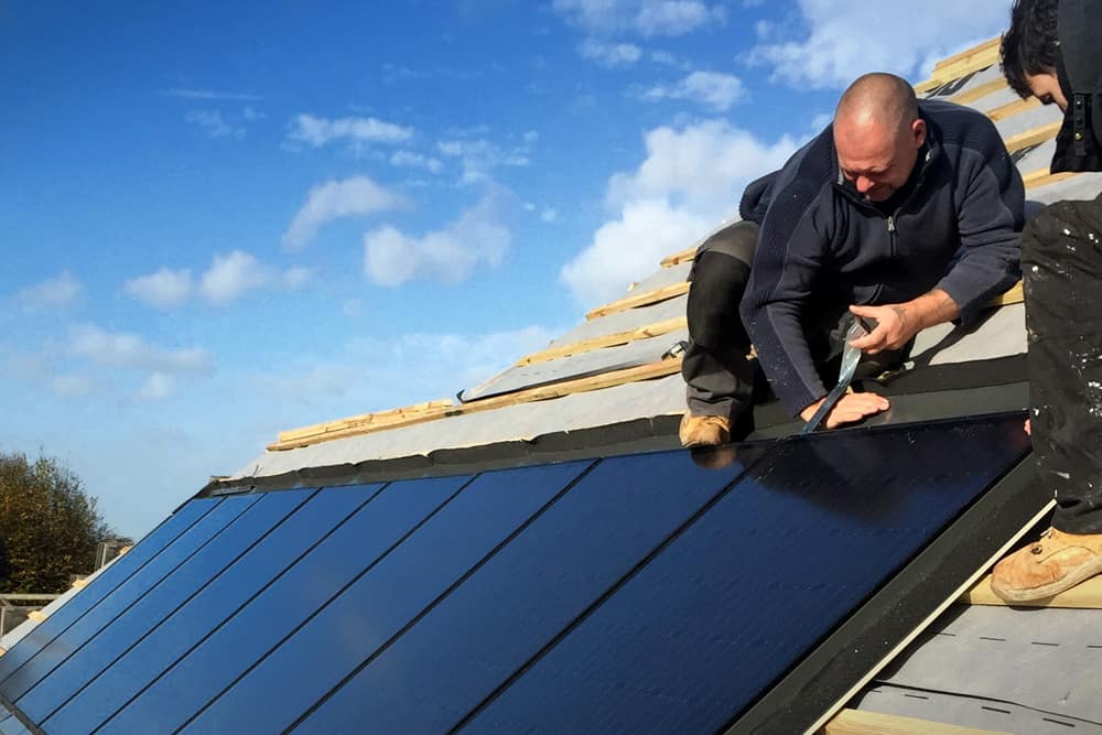 Roofer installing flashing on Marley solar panels